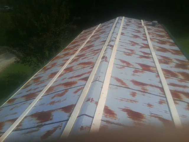 Rusted metal roof panels with new wood purlins before replacement — Storm Damage Roof Repair in Lempster by Roofing Brothers