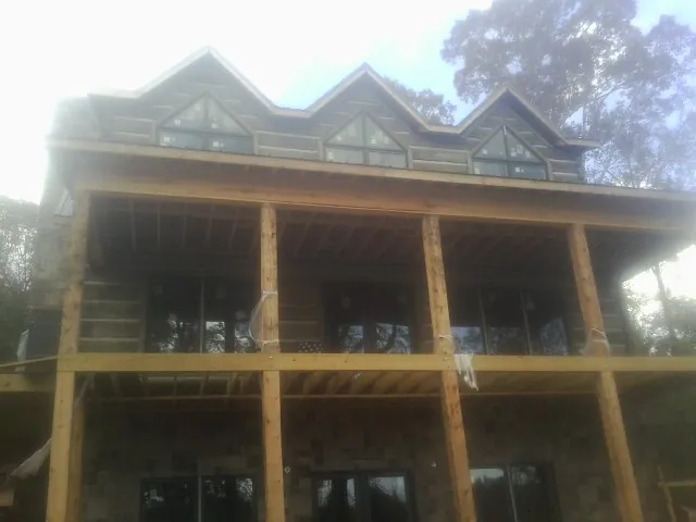 Dormers and porch framing on a large log home under construction — Roof Coating work by our crew in Lempster