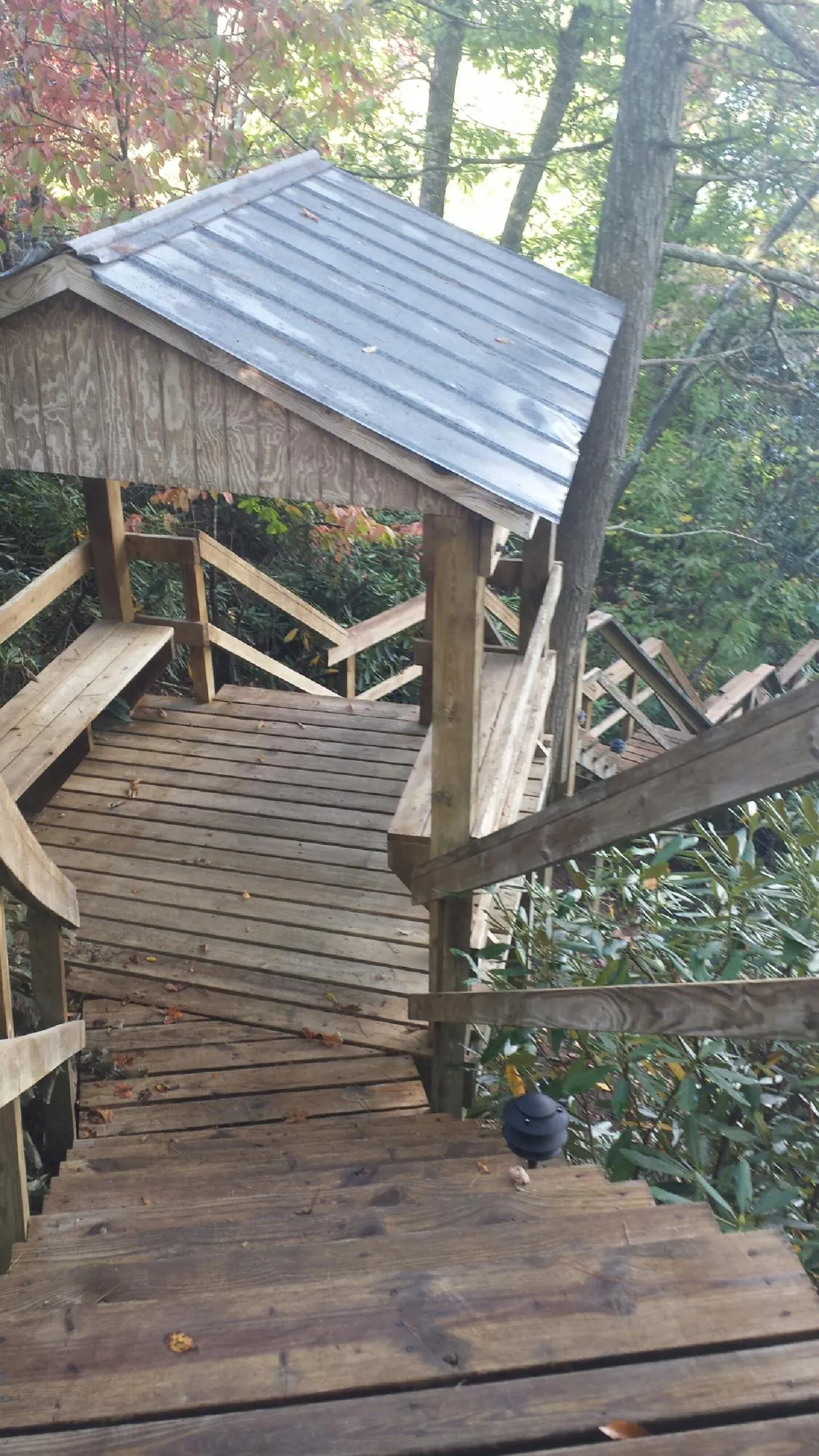 Metal roofed shelter over wooden steps on a wooded walkway — Skylight Repair & Installation work by our crew in Lempster